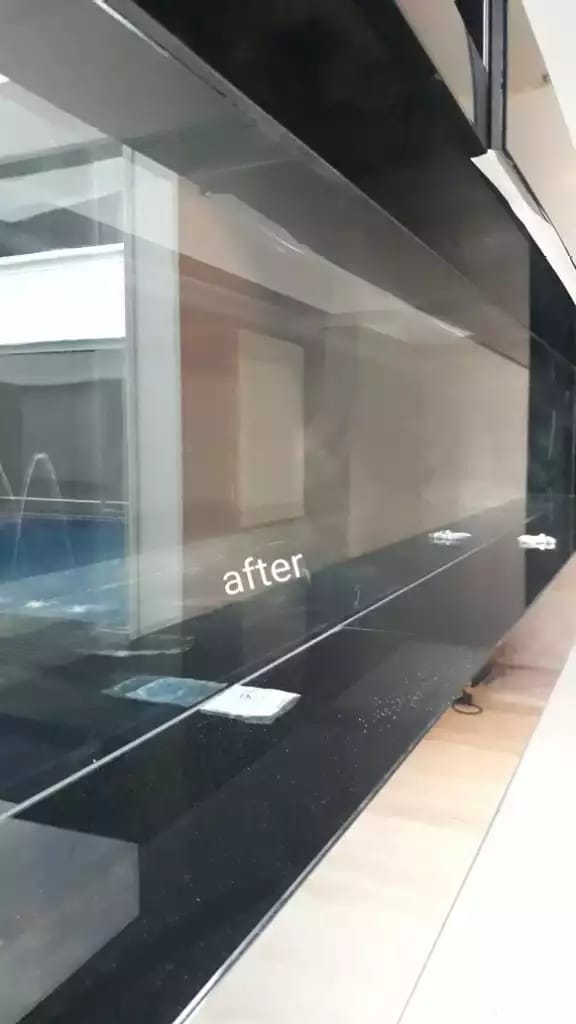 Long aquarium-style display front with room reflections and its original after label