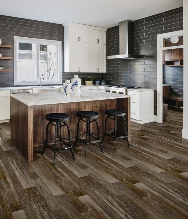 Brown plank-style flooring around a kitchen island with three bar stools